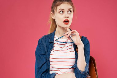 Sırt çantalı neşeli bir kadın saçını tutan genç bir sırt çantası öğrencisi.