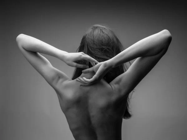 Ładna kobieta pozowanie nagi powrotem studio czarno-białe zdjęcie — Zdjęcie stockowe