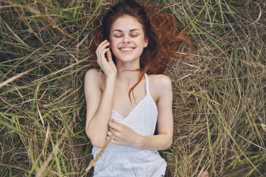 Neşeli kadın çimenlerin üzerinde uzanıyor. Yaşam tarzı dinleniyor.