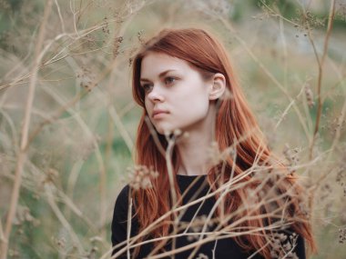 Tatlı kızıl saçlı kadın çimenleri yaz doğasında var.