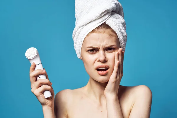 Woman with towel on head naked shoulders massager cosmetology skin care — Stock Photo, Image