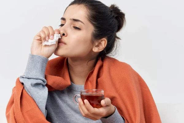 Mujer con una taza de té escondida detrás de una manta en casa infección por resfriado —  Fotos de Stock