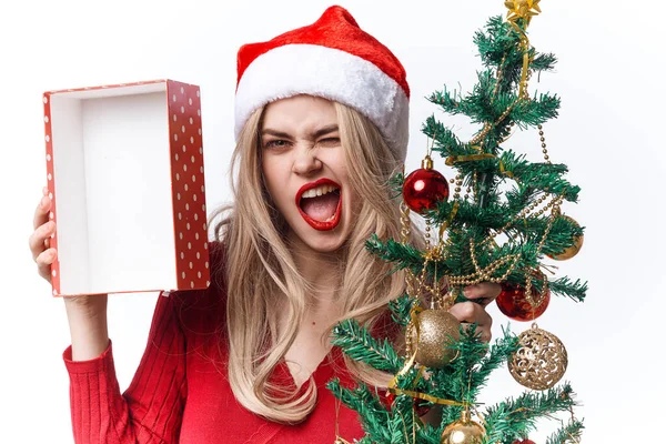 Hezká žena nosí Santa klobouk dárek vánoční dekorace světlo pozadí — Stock fotografie