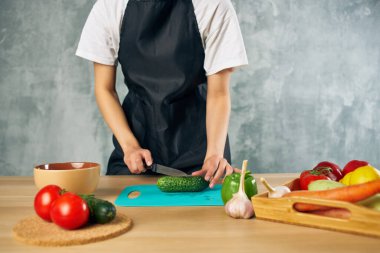 Siyah önlüklü kadın evde vejetaryen salata diyeti yapıyor.