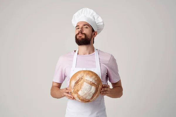 Un uomo in un panettieri uniforme pane di cottura — Foto Stock