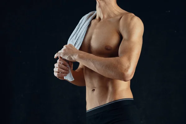 Un homme avec une presse pompée en short noir gymnase fond sombre — Photo