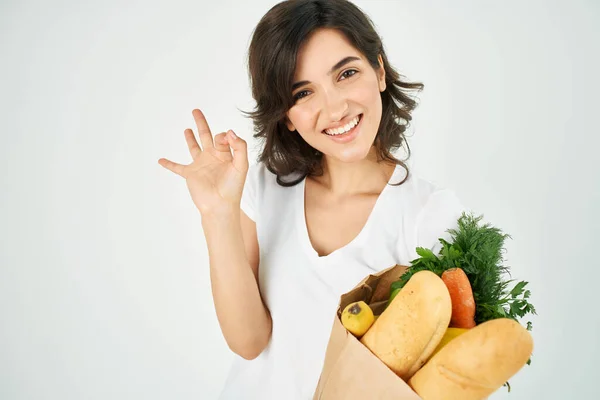 Cute brunette in white t-shirt package with vegetables groceries supermarket — Stock Photo, Image