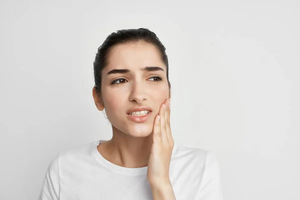Mulher de t-shirt branca segurando rosto dor de dente tratamento odontológico — Fotografia de Stock