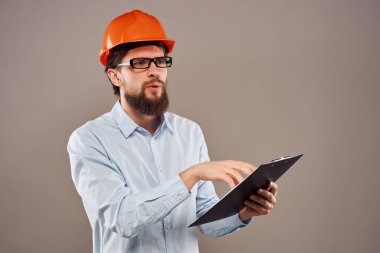 Sakallı adam elinde belgelerle koruyucu üniforma çiziyor.