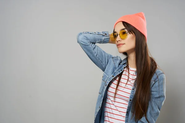 Mujer en rosa sombrero amarillo gafas casa hipster gris fondo — Foto de Stock