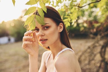 Güzel bayan dışarıda yapraklarla pozisyon alıyor. Yüksek kalite fotoğraf