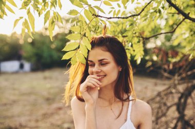 Yeşil yaprakları olan çekici bir kadın. 