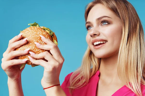 Schattig blond in roze shirt hamburger snack plezier — Stockfoto