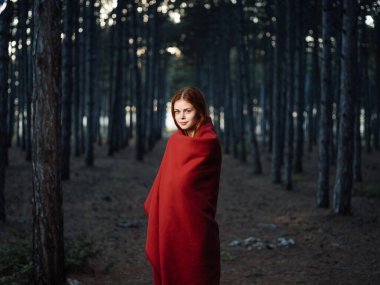 Ormanda kırmızı battaniyeli bir kadın. Yüksek kalite fotoğraf