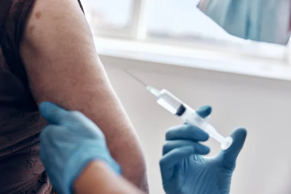 Man läkare ger en injektion vaccin pass sjukvård — Stockfoto