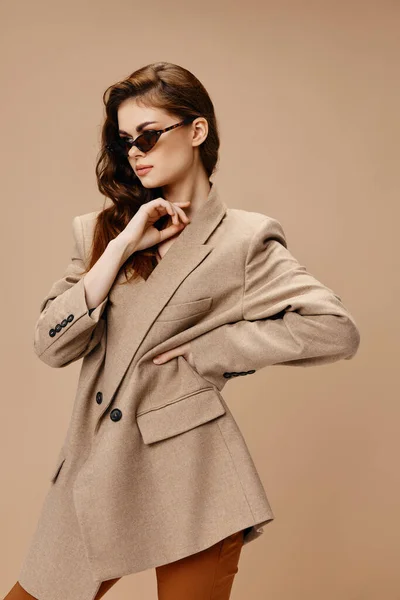 Glamorous lady with glasses and a coat holds her hand at the waist — Stock Photo, Image