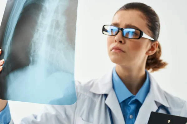Жінка-радіолог дивиться на рентген крупним планом оглядову лікарню — стокове фото