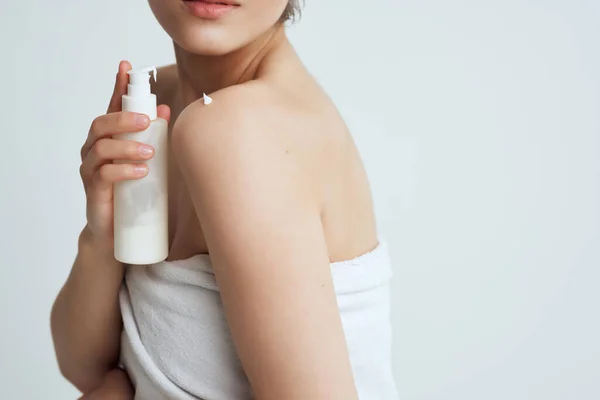 Kvinna med handduk nakna axlar lotion ren hudvård — Stockfoto