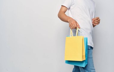 Çantalar bir adamın elinde, alış veriş yapıyorlar.