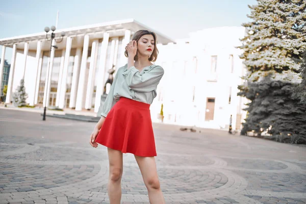 빨간 치마를 입고 도시 밖을 걷고 있는 아름다운 여인 — 스톡 사진
