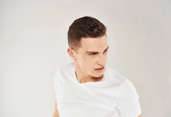 Man in wit t-shirt emoties boos blik studio — Stockfoto