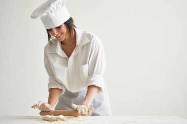 Kadın fırıncı şef üniforması pizza hamuru ve makarna yapıyor.