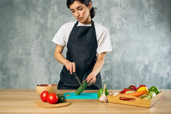 Femme en tablier noir déjeuner à la maison végétarien alimentation salade régime — Photo