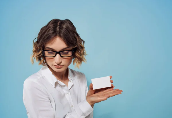 Biznes kobieta w okularach z wizytówkami w rękach reklama studio niebieskie tło — Zdjęcie stockowe