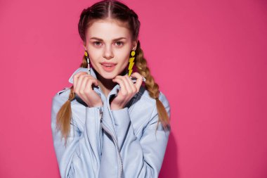 Atkuyruklu neşeli kadın mavi ceketli modern moda pembe arka planlı.