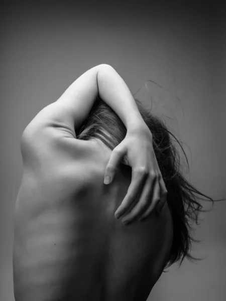 Donna che tiene le mani sulla schiena vista posteriore foto in bianco e nero — Foto Stock