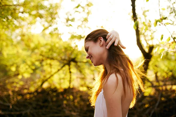 Kvinna i vit klänning rätar ut håret utomhus gröna löv natur — Stockfoto