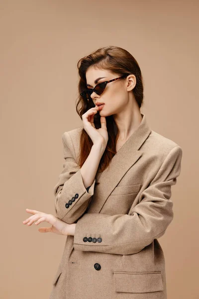 Ceketli ve güneş gözlüklü güzel bir kadının portresi. — Stok fotoğraf