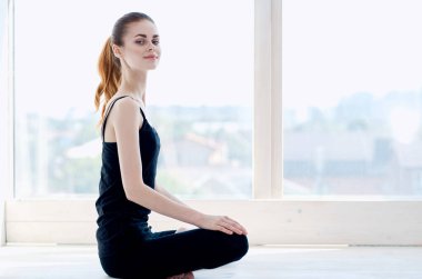 Kadın pencere meditasyonunun yanında egzersiz egzersizi yapıyor