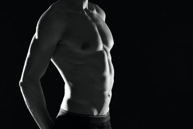 Şişirilmiş vücudu olan atletik bir adam. Siyah-beyaz fotoğraf erkek egzersizi.
