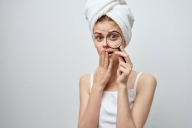 Elinde büyüteçle güzel bir kadın kozmetoloji stüdyosu