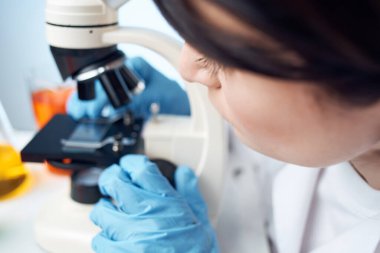 Kadın doktor tıbbi önlük kimyasal çözelti mikroskobu incelemesi