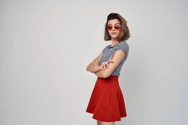 Mooie vrouw in rood rok in gestreept t-shirt elegante stijlvolle licht achtergrond — Stockfoto