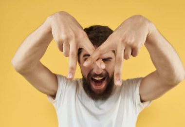 Beyaz tişörtlü sakallı adam stüdyo eğlencesine poz veriyor.