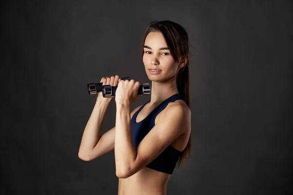 Sport brunette met halters in handen workout donker achtergrond fitness — Stockfoto