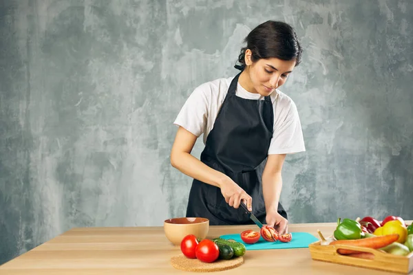 Femme au foyer sur la cuisine coupe légumes planche à découper — Photo