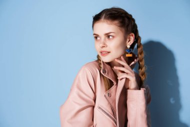 Pembe ceketli, saçları örgülü, kızıl saçlı kadın. Moda eğilimi mavi arka plan.