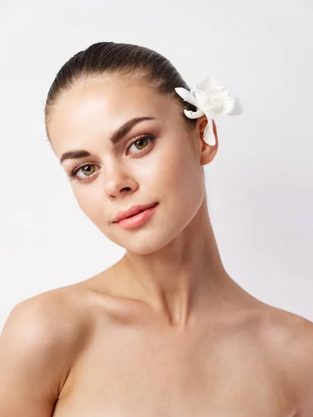 Bella donna con spalle nude cosmetici pelle chiara fiore bianco — Foto Stock