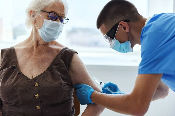 Man läkare som ger en injektion immunförsvar i medicinska masker — Stockfoto