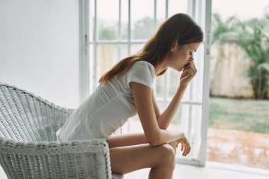 Kadınlar düşünceli bir şekilde evde oturur. Bu yalnızlık tatminsizliği.