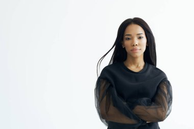 Siyah elbiseli güzel kadın makyajlı uzun saçlı poz veriyor.