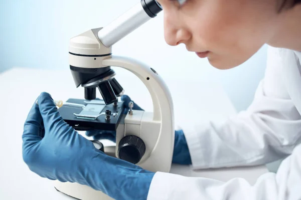 Mujer mirando a través de un microscopio de diagnóstico de investigación científica de cerca —  Fotos de Stock