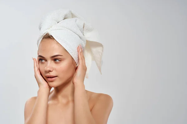 Kvinna med en handduk på huvudet bara axlar närbild ren hud — Stockfoto