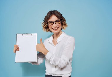 Elinde kartvizit olan beyaz gömlekli bir iş kadını kahve fotokopisi arkaplanını belgeliyor