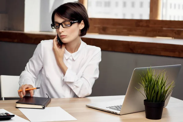 Businesswoman u stolu s brýlemi sebevědomí světlo pozadí — Stock fotografie