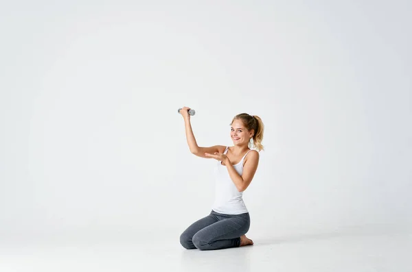 Athletic woman sitting on the floor exercise dumbbells fitness — Stock Photo, Image